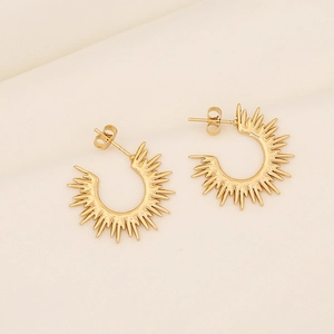 Elegant gold celestial sunburst C-shaped hoop earrings on neutral textured background