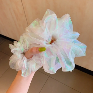 Iridescent white organza scrunchie with laser holographic effect on female wrist