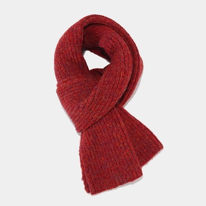 Close-up of deep red chunky knit scarf showing thick ribbed texture and marled yarn detail