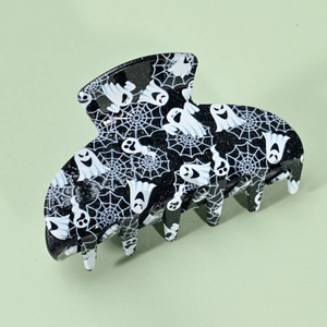 Détail de la pince à cheveux Halloween avec fantômes blancs et toiles sur fond noir brillant