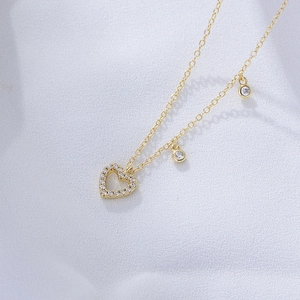 Macro shot of gold S925 silver hollow heart necklace with sparkling zircon crystals