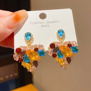 Gros plan de boucles d'oreilles en cœur avec zircons colorés et tige en argent S925