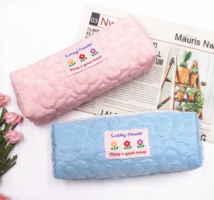 Detail of pink and blue quilted flower pencil cases with Lucky Flower woven labels