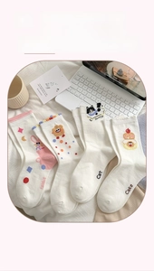 Détail de chaussettes en coton de style japonais avec broderies chat, lapin et gâteau