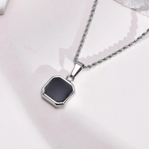 Dettaglio della collana con ciondolo quadrato nero geometrico e catena argento