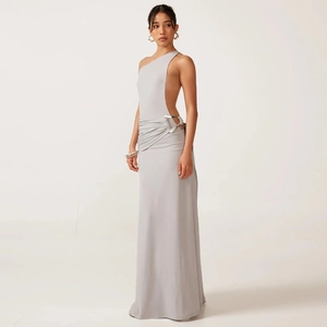 Détail d'une robe grise à une épaule avec découpe à la taille et boucle en métal