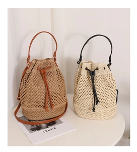 Detailed close-up of straw bucket bags with leather straps and drawstring closure