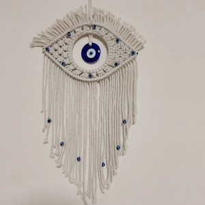 Handmade cream macrame evil eye wall hanging with woven fringe and blue beads decor