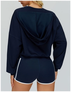 Rear view of loose-fit navy hooded sweatshirt and athletic shorts with white piping trim