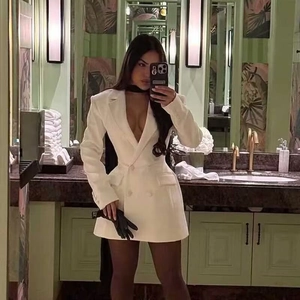 Abito blazer bianco doppiopetto con profondo scollo a V e taglio sfiancato in hotel di lusso