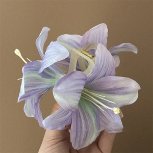 Detailed close-up of a purple lily flower hair claw clip with realistic fabric petals