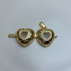 Detailed view of an open golden heart locket with pave rhinestones and hollow design