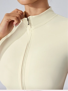 Détail du body de yoga crème avec fermeture éclair argentée et tissu élastique de qualité