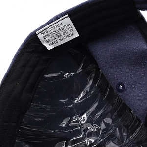 Detailed macro view of the washing label showing 80% cotton material on the navy baseball cap