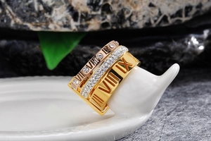 Detailed macro view of triple-layer Roman numeral ring with gold and silver finishes