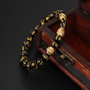 Bracelet ethnique en onyx noir avec perles mantra dorées et breloque tête de bouddha évidée