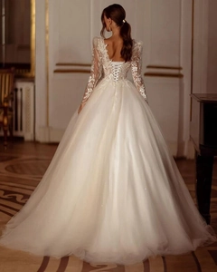 Détails exquis du dos d'une robe de mariée en dentelle ivoire avec dos en V et ruban