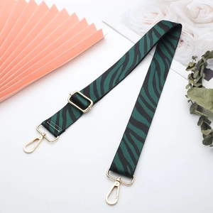 Detail of green zebra canvas strap with gold metal hardware on decorative background