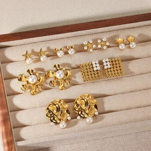 Miniature gold star and pearl earrings set in a velvet jewelry organizer box