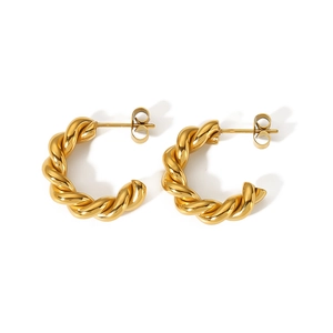 Detailed view of gold twisted C-shaped hoop earrings with polished rope texture