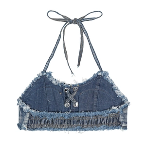Dettaglio di un crop top denim blu con allacciatura frontale e finiture con frange