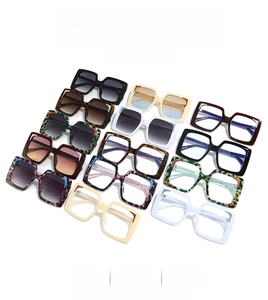 Flat lay of square sunglasses in various colors including tortoiseshell and marble patterns