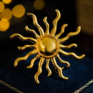 Vintage golden sunburst brooch with wavy rays on a premium blue velvet jewelry box
