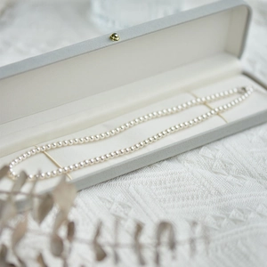 Elegant 925 silver round white pearl necklace displayed in a luxury grey jewelry box