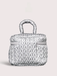 Macro shot of silver quilted travel bag with V-shaped texture and metal handle