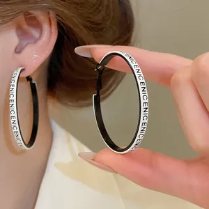 Boucles d'oreilles créoles géométriques en cuir avec imprimé de lettres noir et blanc