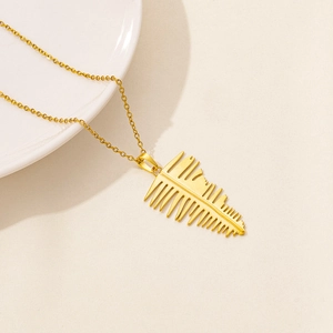 Close-up of golden leaf pendant on a thin cross chain with elegant matte finish