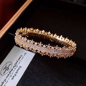 Close-up of 18k gold plated hollow bangle with white crystals in a black jewelry box