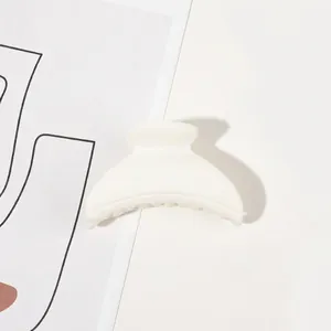 Close-up of white matte finish hair claw clip on minimalist background for styling