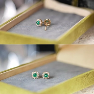 Close-up of S925 silver emerald earrings with small diamonds in a green velvet box