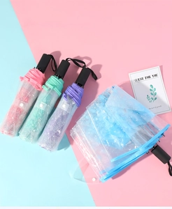Detail of automatic transparent umbrellas with starry patterns in four pastel colors