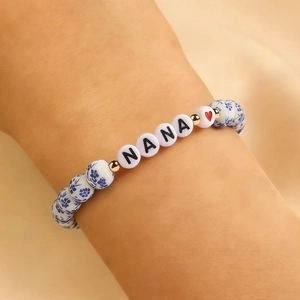 Dettaglio del bracciale NANA in ceramica con motivi blu porcellana e perline dorate