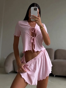 Detail of pink knitted loungewear set with hollow-out pattern and tie-front design