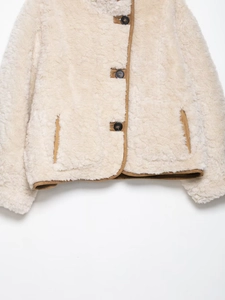 Detailansicht beige Webpelzjacke mit brauner Paspelierung und schwarzen Kunstharzknöpfen