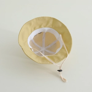 Detail of yellow sun hat interior showing adjustable chin strap and inner lining