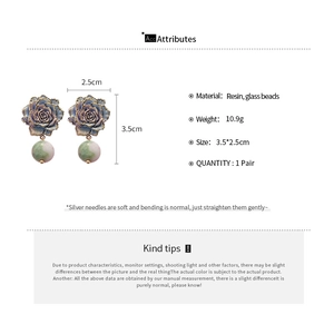 Detailed macro view of retro rose earrings with resin flowers and glass bead drops