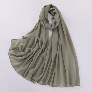 Close-up of green pearl chiffon shawl with sparkling rhinestones on a white background