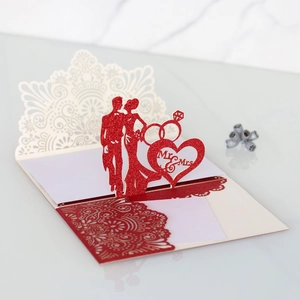 Macro shot of 3D laser-cut Mr & Mrs silhouette and heart detail on glitter wedding card
