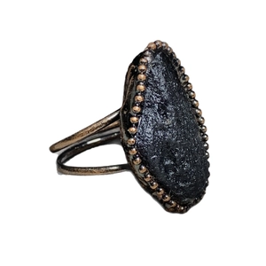 Adjustable bronze ring with oval black meteorite stone and bead edge detailing