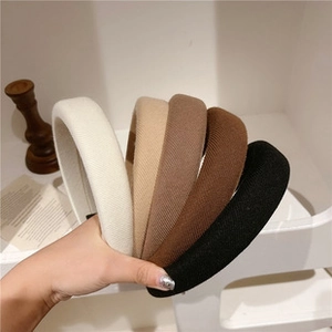 Detailed side view of thick knitted headbands in neutral colors like beige and brown