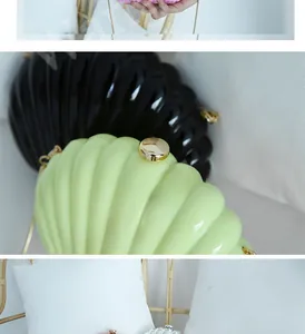 Detail of shell-shaped acrylic clutches with striped texture and golden ball clasp