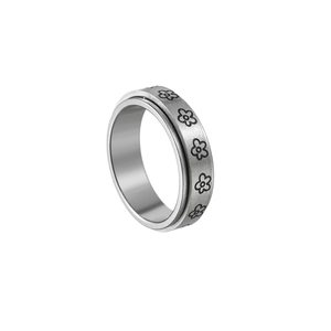 Detailed view of rotating silver steel ring with engraved floral pattern on white background