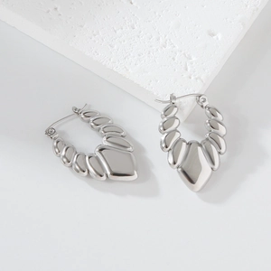 Macro detail of silver stainless steel earrings with textured spiral wave surface