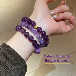 Three-layer natural amethyst bead bracelet with a gold butterfly charm on female wrist