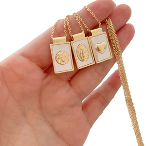 Gold-plated natural shell necklace with Mother Mary and heart pendants held in hand
