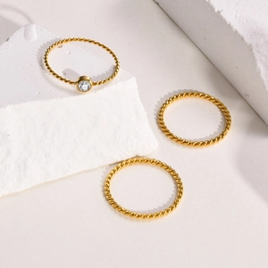 Dreiteiliges Gold-Edelstahl-Ring-Set mit gedrehten Bändern und rundem klarem Schmuckstein
